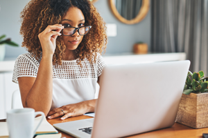 Woman looking at computer with her eyeglasses down