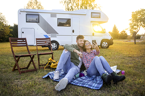 happy couple camping with rv