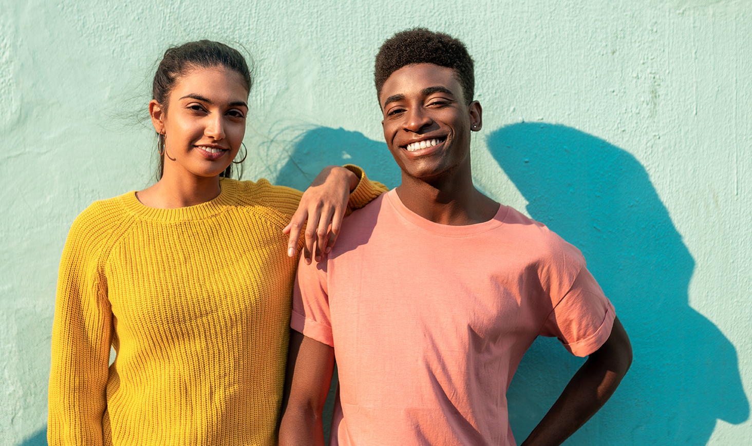 Young friends standing outside along a wall