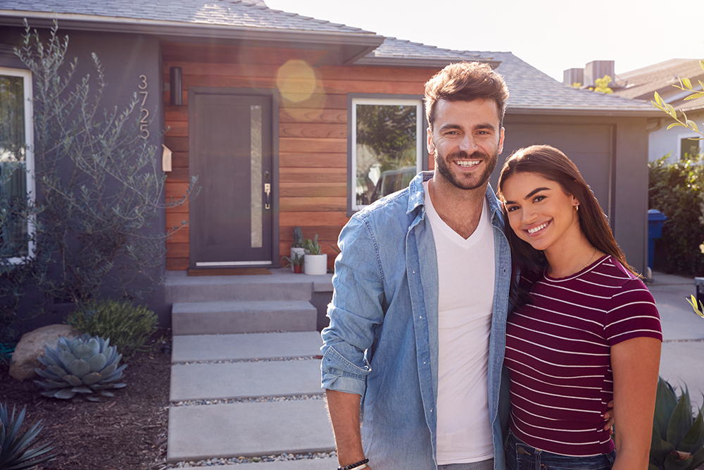 couple standing in front of house