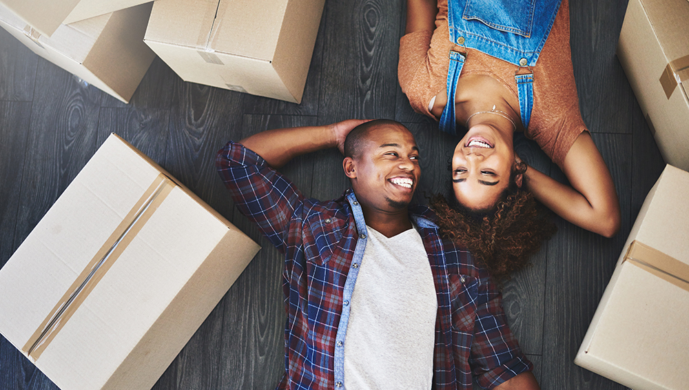 happy couple laying on floor with moving boxes