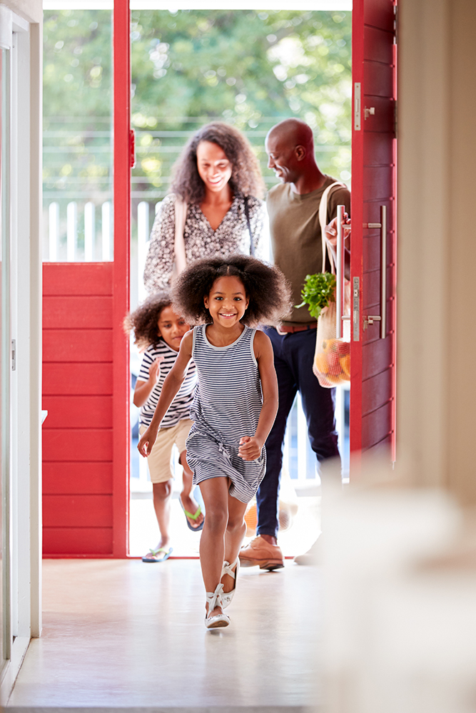 couple with kids opening door and entering home