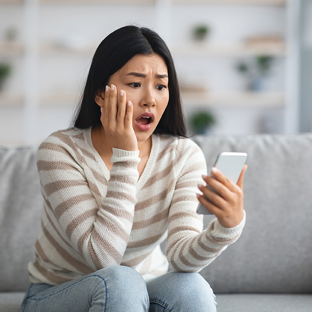 woman looking at scam on phone