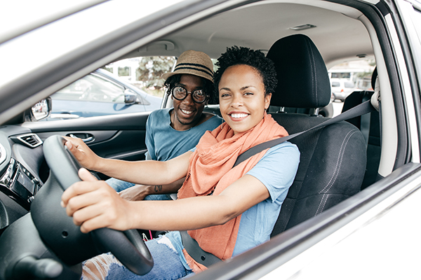 happy driver sitting in driver's seat of vehicle