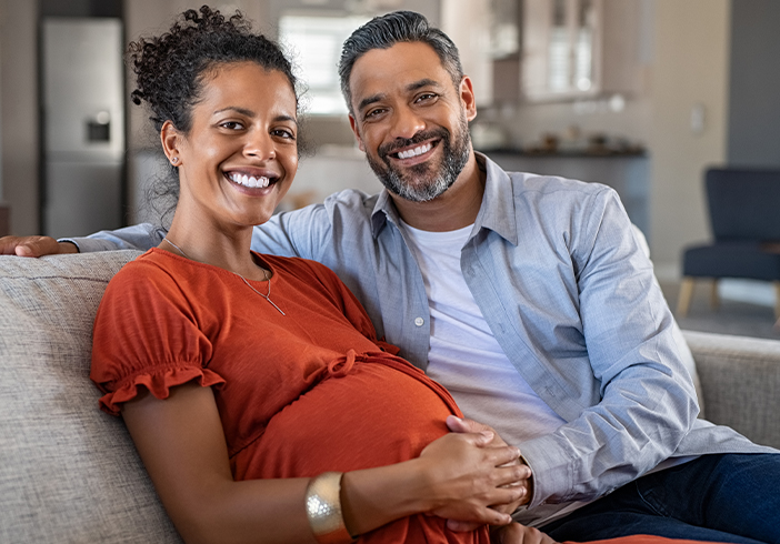 Pregnant couple sitting on a couch