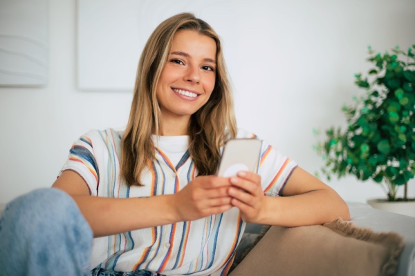 Young woman holding cell phone in hand