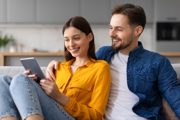 Couple looking at tablet on the couch