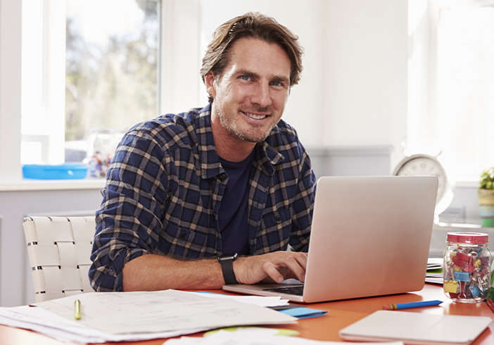 Man sitting at a desk in front of a laptop