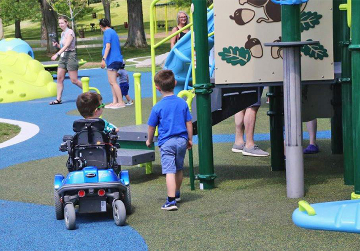 Two children enjoying a Genisys Credit Union sponsored inclusive park