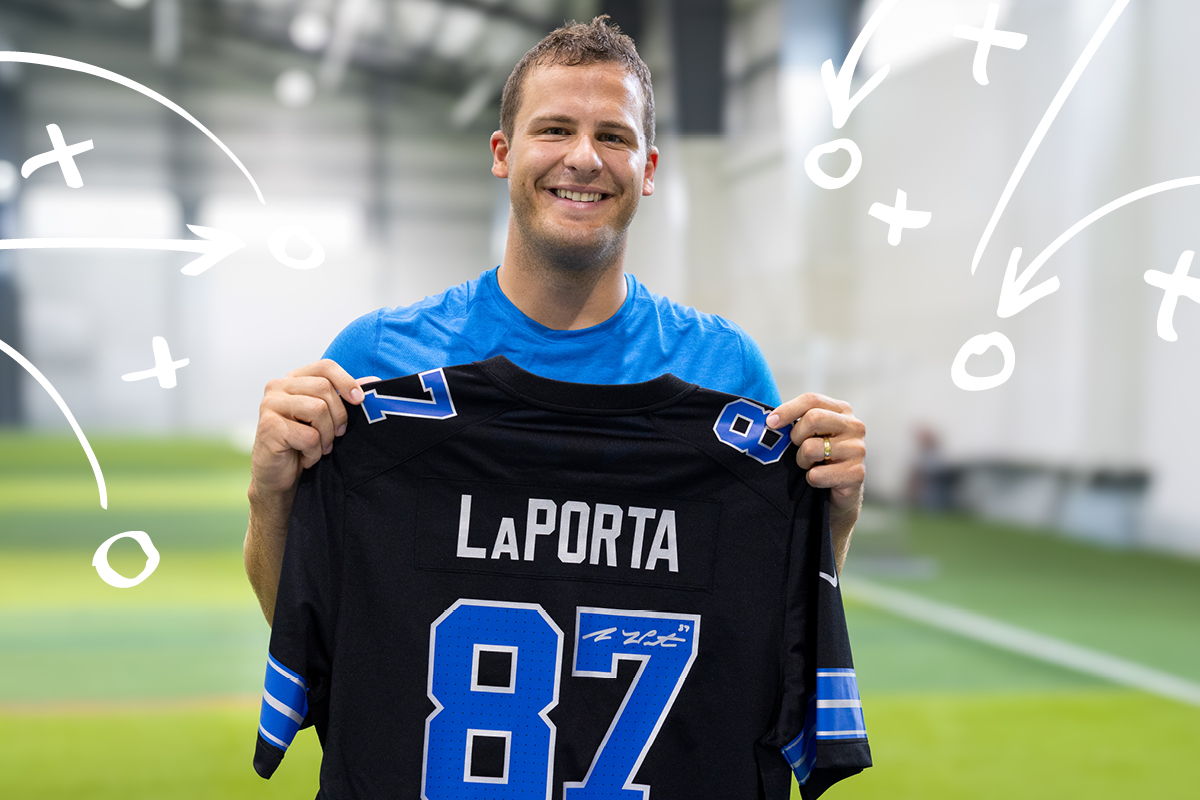 Sam LaPorta holding a jersey he autographed