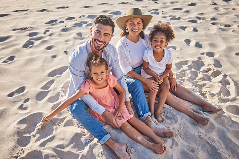 Family sitting in the sand on a beach