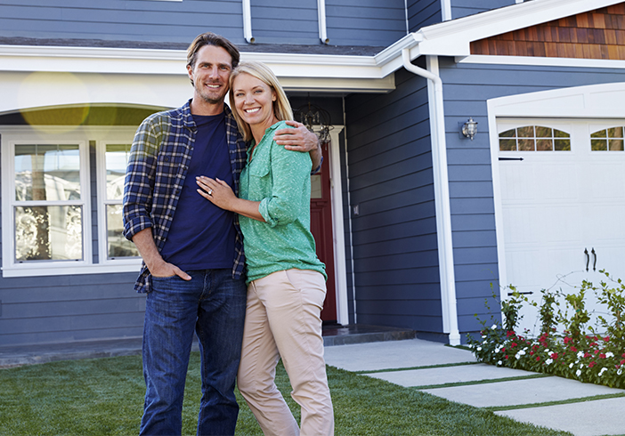 couple standing in front of their home