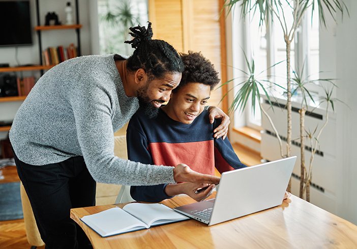 father and son looking at computer together