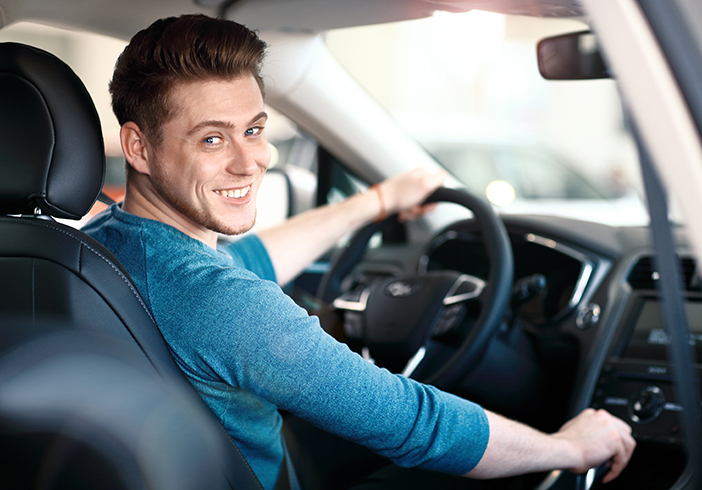 man sitting in drivers seat of car
