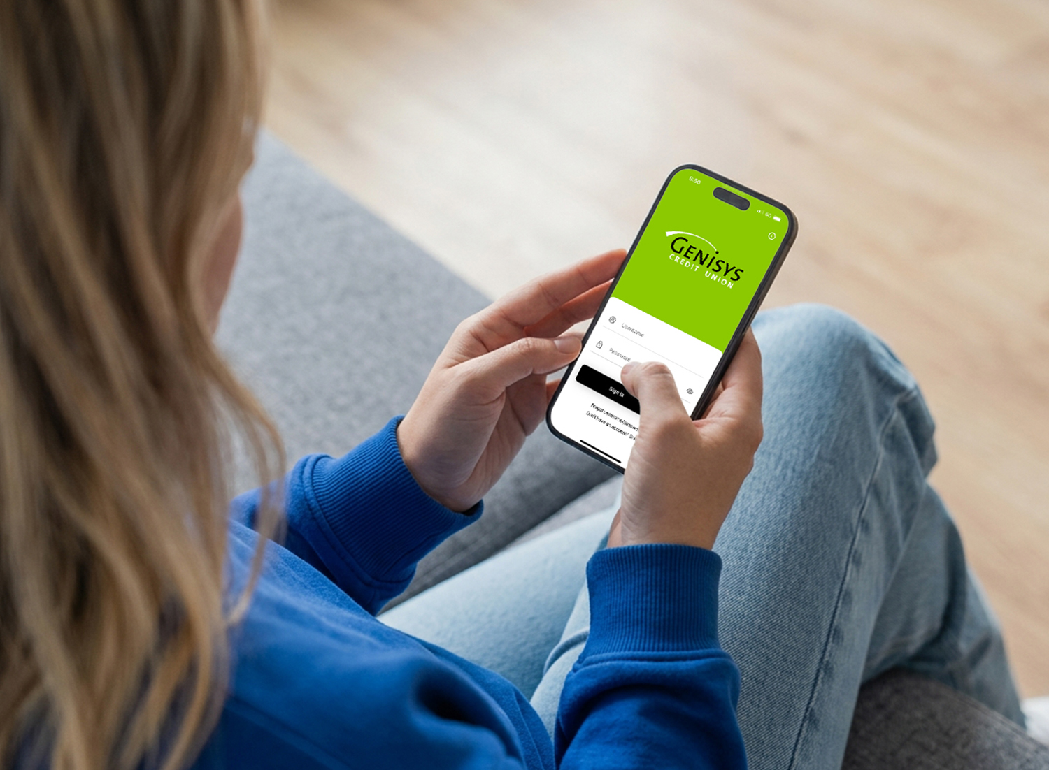 woman holding her smartphone with the Genisys Mobile App on the screen