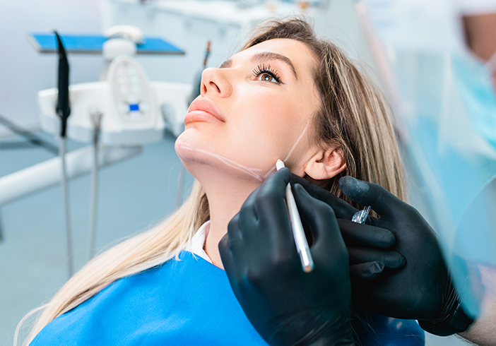 A doctor drawing lines on patient's face for a cosmetic procedure