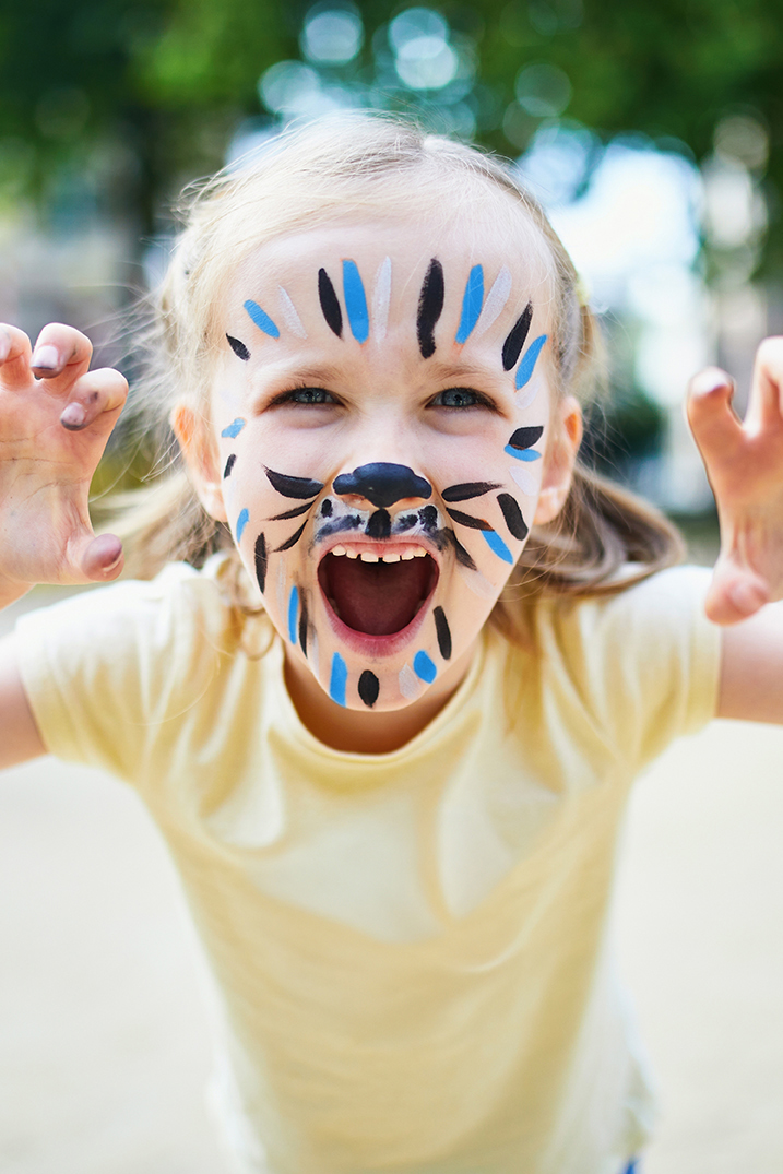 little girl with face painted like a lion