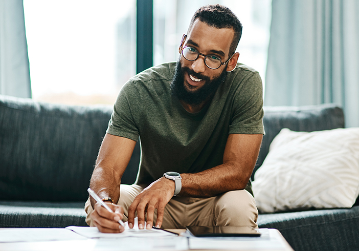Man on the couch in front of papers and calculator