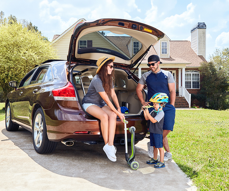 Family outside home near car