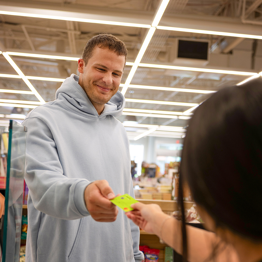 Detroit Lions player Sam LaPorta holding a Genisys Debit Rewards Mastercard