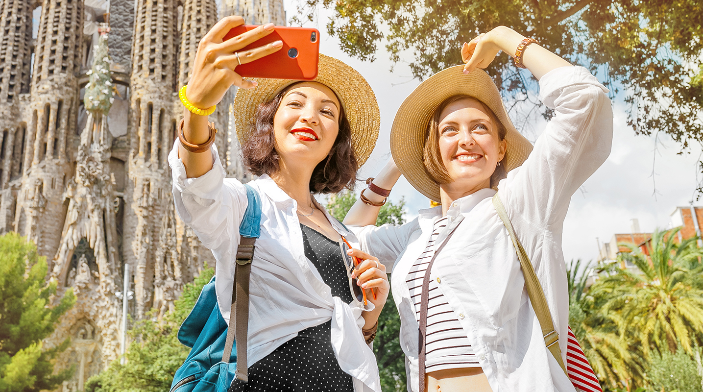 Two women in Spain taking a selfie in front of a cathedral
